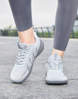 Woman walking outdoors in light gray Terra B3 wide toe box barefoot shoes