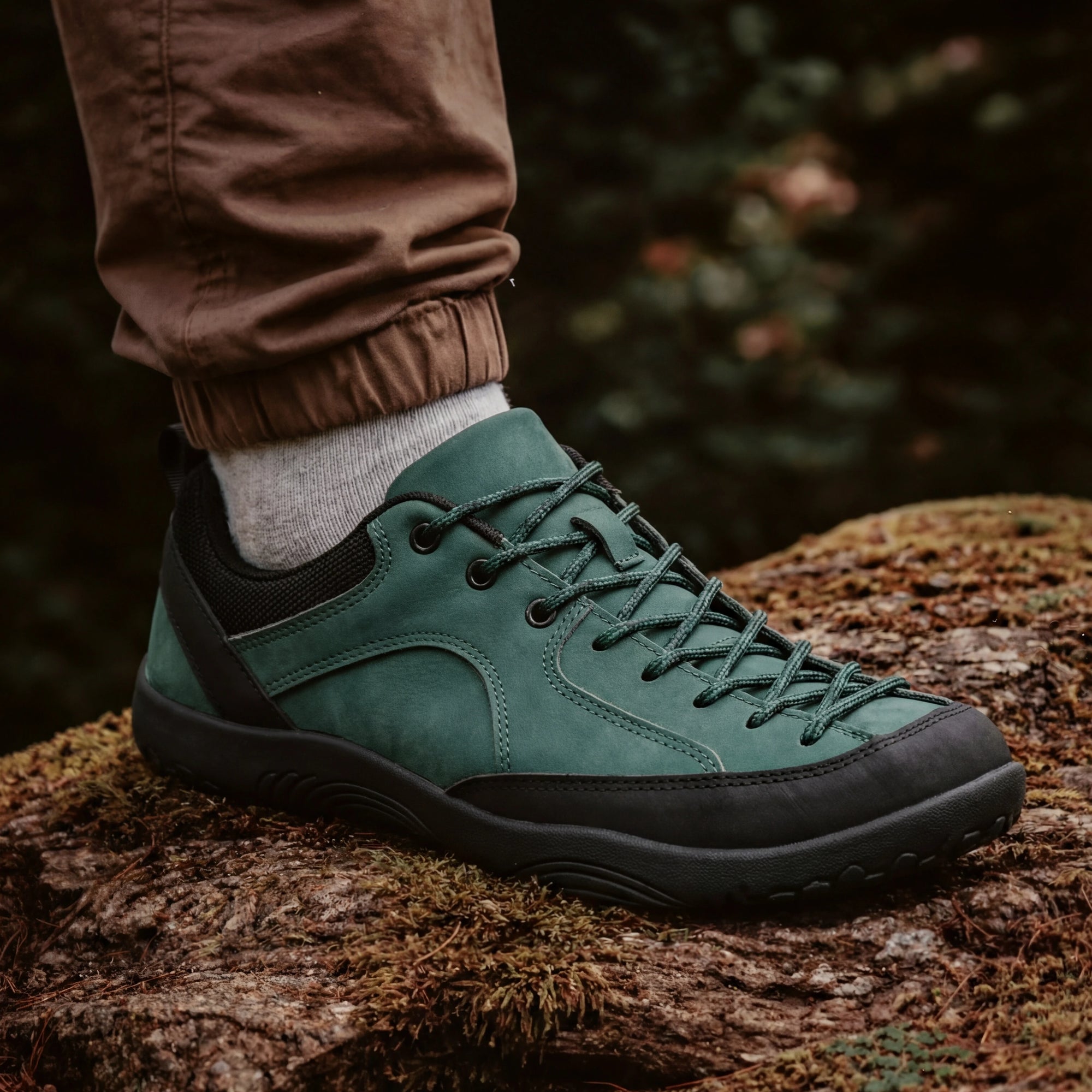 Close-up of DANNTO Veld I green   barefoot shoes worn outdoors on a moss-covered log