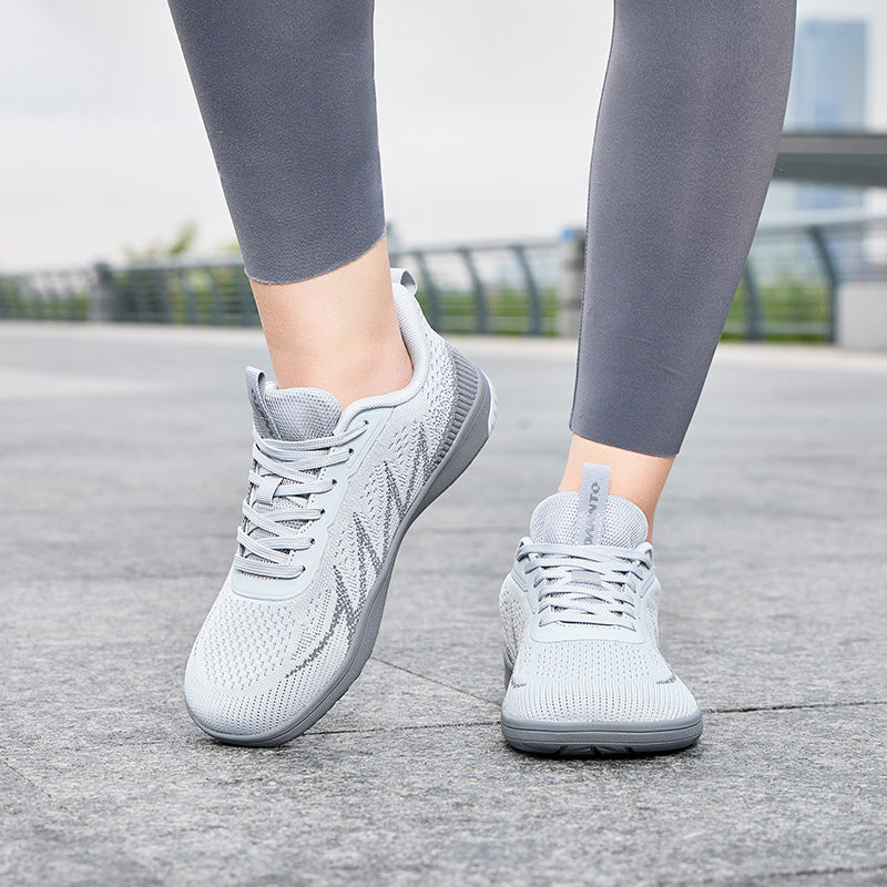 Woman walking outdoors in light gray Terra B3 wide toe box barefoot shoes