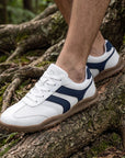 Dannto Frond - Non-Slip Zero Drop Barefoot Sneakers white shown being worn while walking over tree roots outdoors
