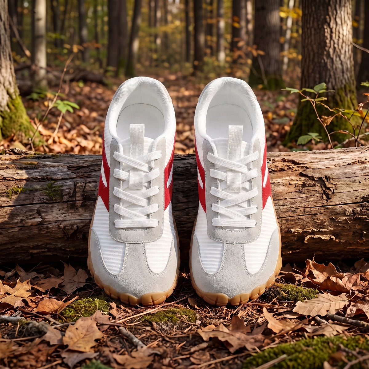 DANNTO Purus Men's and Women's Wide Toe Box Barefoot Shoes in White Shown Side by Side on a Forest Floor in Front of a Fallen Log.