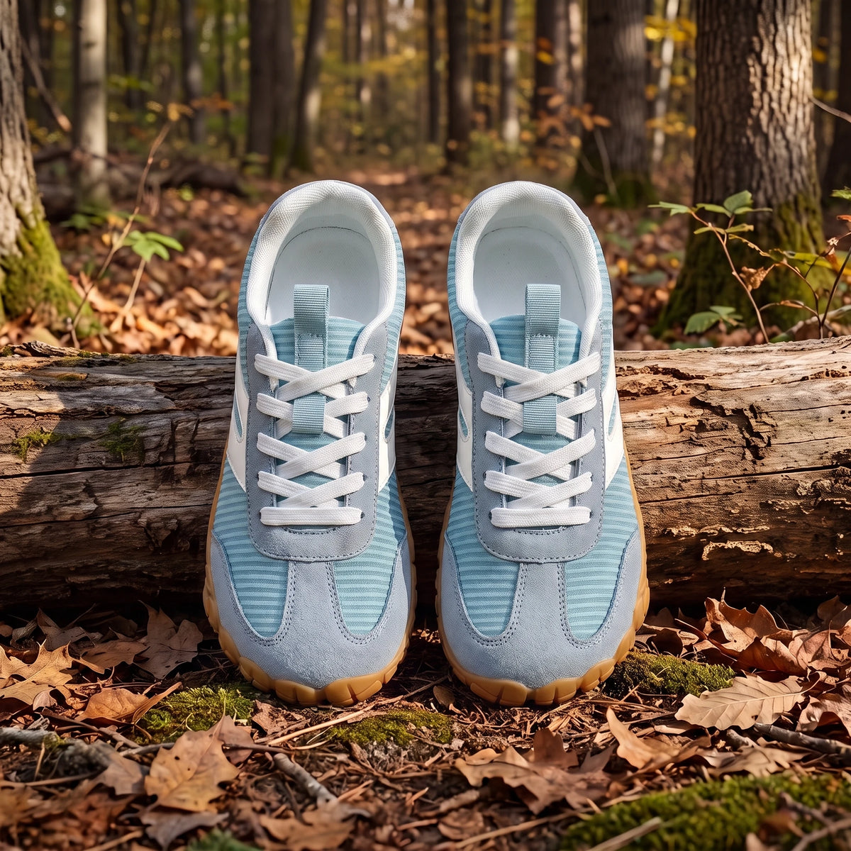 DANNTO Purus Men's and Women's Wide Toe Box Barefoot Shoes in Blue Shown Side by Side on a Forest Floor in Front of a Fallen Log.