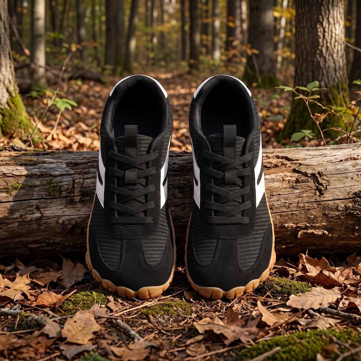 DANNTO Purus Men's and Women's Wide Toe Box Barefoot Shoes in Black Shown Side by Side on a Forest Floor in Front of a Fallen Log.