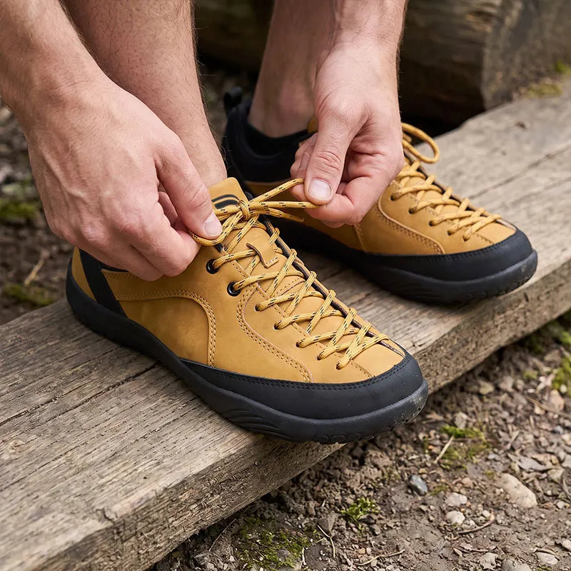 Dannto Veld I - man tying the laces of 3E wide toe box barefoot shoes in tan in outdoors
